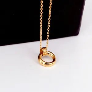 Détail d'un pendentif double anneau en or poli montrant un style esthétique épuré