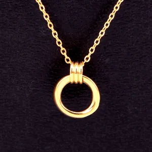 Vue détaillée d'un collier avec pendentif double anneau géométrique en acier titane doré