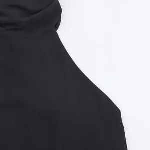 Κοντινό πλάνο του κομψού μαύρου υφάσματος και της ντραπέ λαιμόκοψης αυτού του κομψού τοπ.