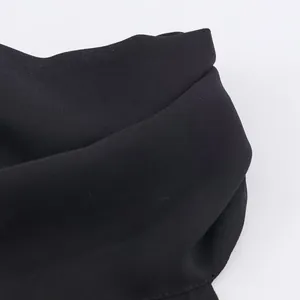 Κοντινό πλάνο λεπτομέρειας μαύρου σιφόν halter neck τοπ που δείχνει την υφή του