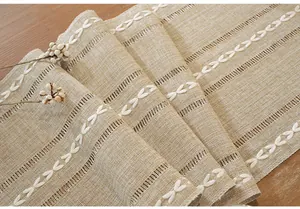 Close-up of American style cotton linen table runner with elegant white leaf embroidery