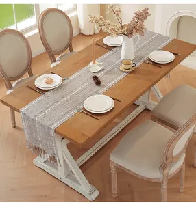 Close-up of American style cotton linen table runner with tassels on a wooden dining table