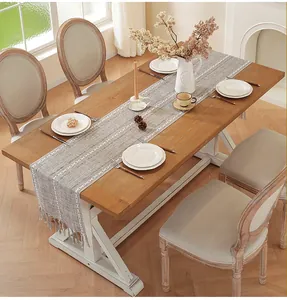 Detailed view of grey cotton linen table runner with white patterns and tassels