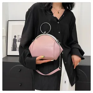 Vue détaillée du sac à main rose en forme de coquille avec poignée anneau argenté