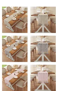 Linen table runners in beige, grey, and pink with tassel details on a wooden dining table