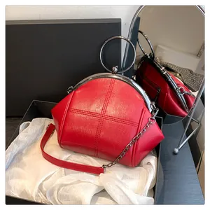 Gros plan d'un sac shell rouge avec texture point de croix et bandoulière en chaîne