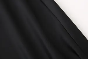 Detalle macro que muestra la textura suave y el brillo de una falda midi de satén negro