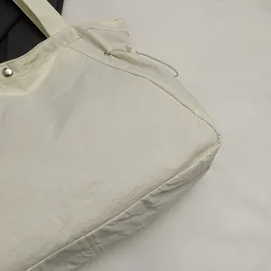 Detailansicht der wasserdichten Nylon-Tragetasche mit Stofftextur und Druckknopf