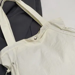 Nahaufnahme einer weißen wasserdichten Nylon-Tragetasche mit Druckknopf und Kordelzug