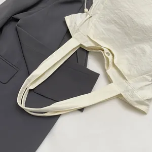 Detailansicht einer leichten, wasserdichten weißen Tragetasche aus Nylon-Stoff.
