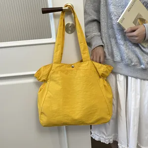 Gelbe wasserfeste Nylon-Tragetasche, die in einem Lifestyle-Ambiente an einem Türgriff hängt.