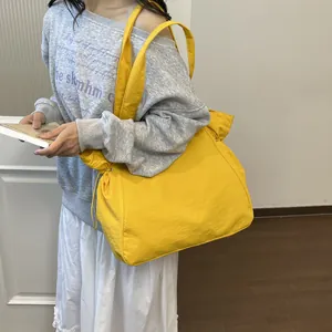 Modell trägt die leuchtend gelbe Nylon-Tragetasche für den Freizeitlook