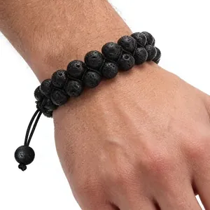 Gros plan d'un bracelet tissé réglable en pierre de lave noire à deux rangs sur le poignet