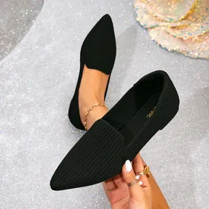 Detailed macro view of black pointed-toe flyknit flats showing fine woven texture