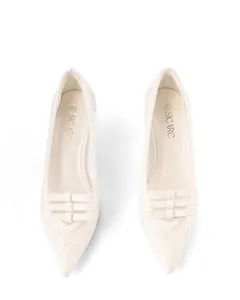 Detailed overhead view of cream pointed-toe pumps with delicate lace and triple bow