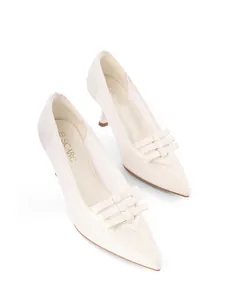 Detailed view of white lace pointed toe high heels with bow accent and slim heel