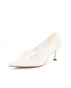 Side profile of elegant white lace kitten heel pumps featuring a tiered bow detail