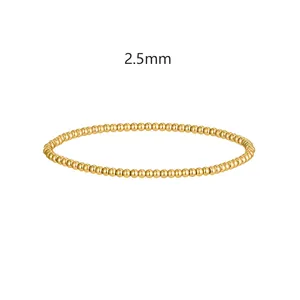 Vista dettagliata delle perle dorate da 2,5 mm su bracciale elastico in acciaio inox