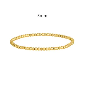 Vista macro di perle in acciaio inossidabile dorato da 3 mm su un bracciale elastico minimal