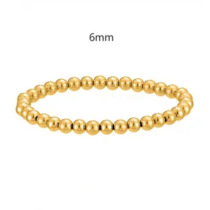 Primo piano del bracciale elastico con perline in acciaio inossidabile dorato da 6 mm su bianco.