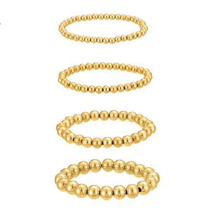 Close-up detail of four gold stainless steel beaded bracelets showing varying bead sizes