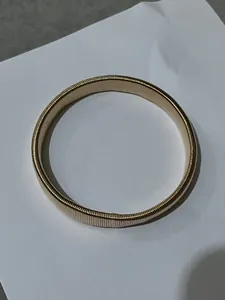 Detailed view of a flexible gold metal spring bracelet designed for men's arm styling