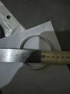 Close-up of a silver metal spring bracelet diameter measurement with a metal ruler