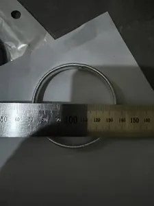 Professional measurement of a silver metal spring armlet showing diameter on a steel ruler.