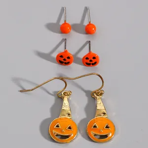 Close-up of three pairs of Halloween orange pumpkin stud and drop earrings set