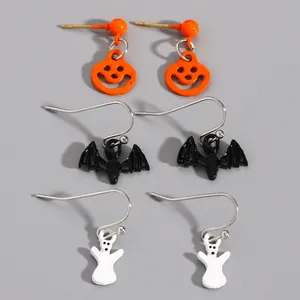 Detail view of Halloween earring set featuring pumpkin, bat, and ghost motifs on gray background.