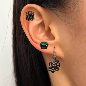 Close-up of Gothic Halloween earrings featuring black spider, cauldron, and web
