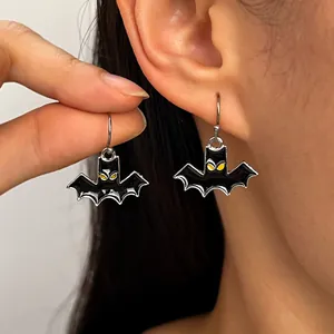 Close-up of gothic black bat earrings with yellow eyes for Halloween jewelry