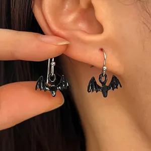 Close-up view of gothic black bat drop earrings worn for Halloween costume jewelry
