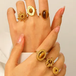 Macro view of vintage gold stainless steel rings set with tiger eye stones on model's hand