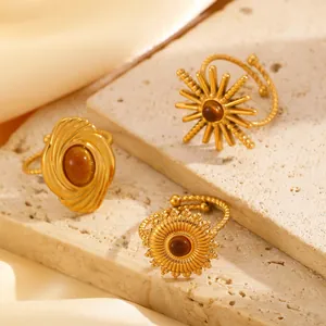 Detailed view of three vintage gold stainless steel rings with tiger eye stone inlays.