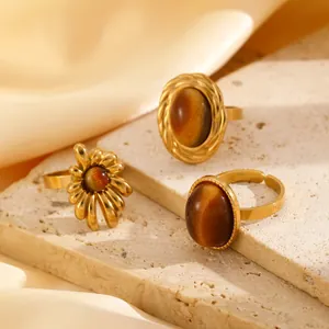 Detail view of vintage stainless steel rings set with tiger eye stones on stone blocks