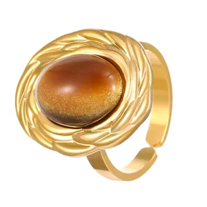 Macro detail of vintage gold stainless steel ring with oval tiger's eye stone inlay
