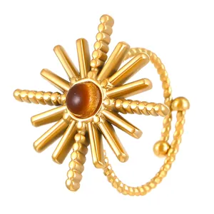 Detailed view of a gold-plated starburst ring featuring a centered brown tiger eye stone.