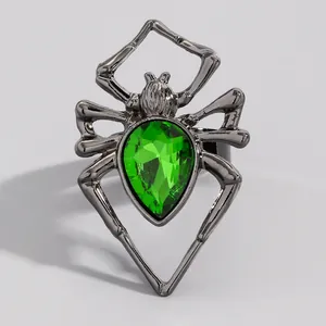 Détail de bague araignée gothique avec une grande pierre précieuse verte en forme de poire