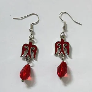 Detalle de pendientes colgantes de estilo kazajo con motivo de pájaro rojo y cuentas