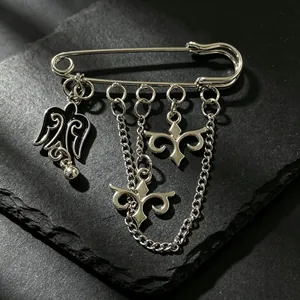 Primer plano de un broche plateado de estilo kazajo con colgantes étnicos y cadenas