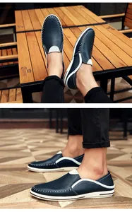 Gedetailleerde weergave van marineblauwe leren loafers met witte contraststiksels
