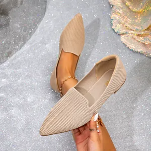 Detailed macro view of beige pointed-toe knit flats showing the intricate woven fabric texture