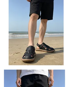 Close-up detail of men's black outdoor fisherman sandals on a sunny sandy beach