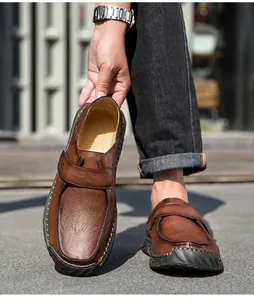 Detailopname van handgestikte bruine leren herenloafers in een retro casual stijl