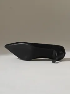 Λεπτομερής προβολή μαύρης γόβας fly-knit με μυτερή μύτη και λεπτό τακούνι.