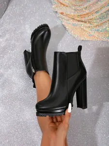 Detailed view of black chunky high heel Chelsea boots with platform sole and round toe