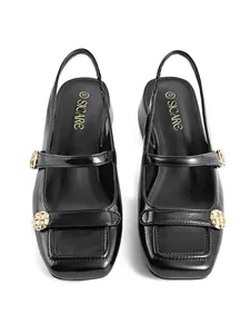 Top view detail of black square-toe Mary Jane slingback heels with gold buckles