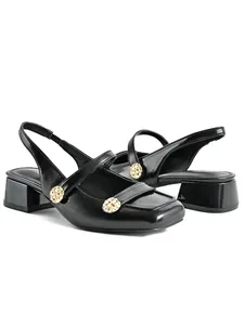 Elegant detail view of black square-toe Mary Jane sandals featuring gold decorative buttons.