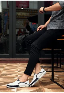 Zijaanzicht van heren loafers van wit en marine leer met witte handgestikte details.